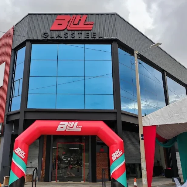 BLH Motor Sungai Udang branch — a black and dark grey corner building with a red BLH MOTOR sign and GLASSTEEL lettering above blue glass windows, a Yamaha Genuine Parts & Accessories sign on the side wall, and a red BLH inflatable arch over the entrance.